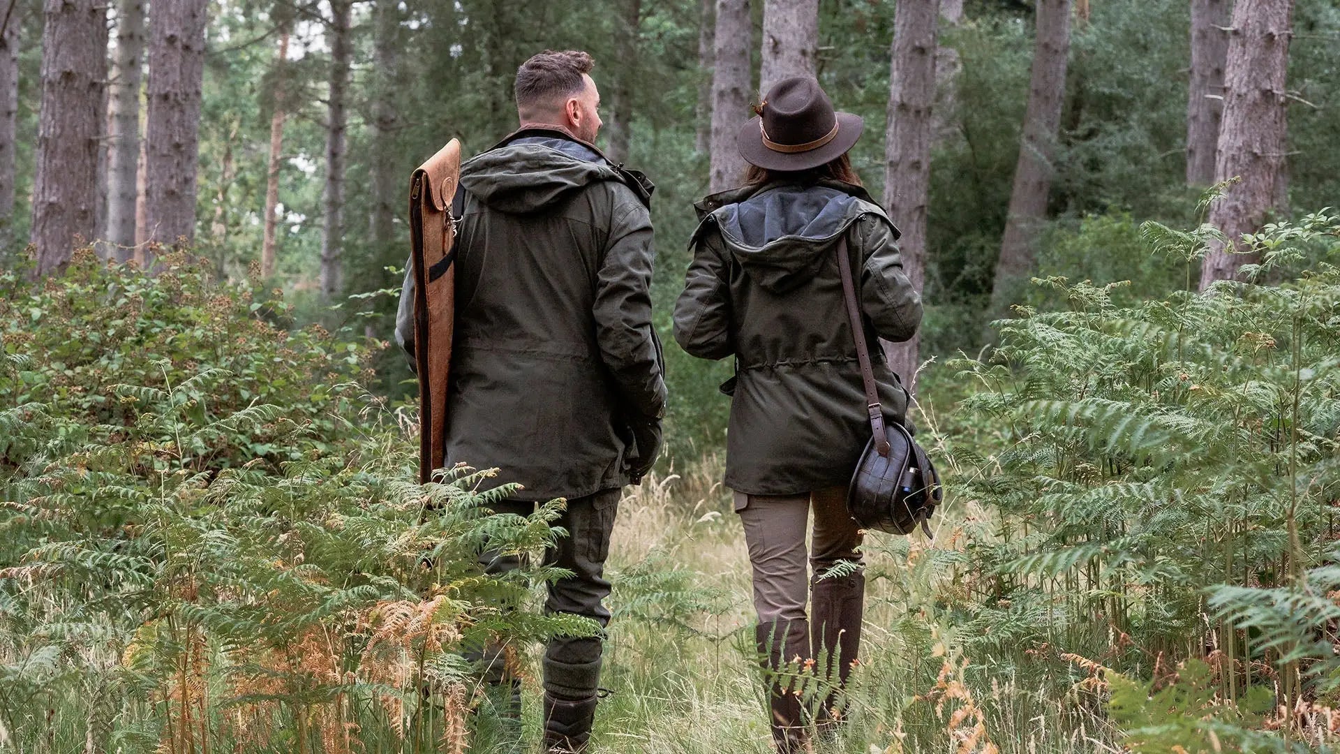 Two people in hunting attire walking through a forest in marsh jackets for ladies marsh style