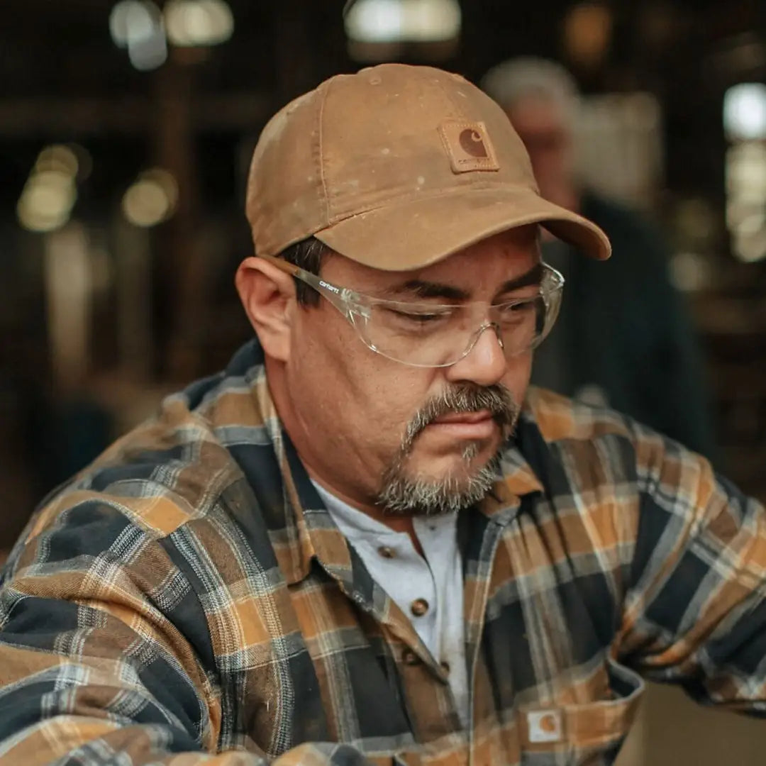 Man wearing safety glasses and Carhartt Canvas Cap for a rugged look
