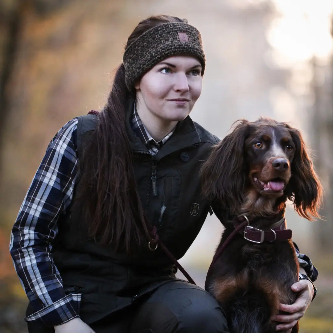 Person with a brown spaniel dog wearing a Deerhunter Ladies Headband outdoors
