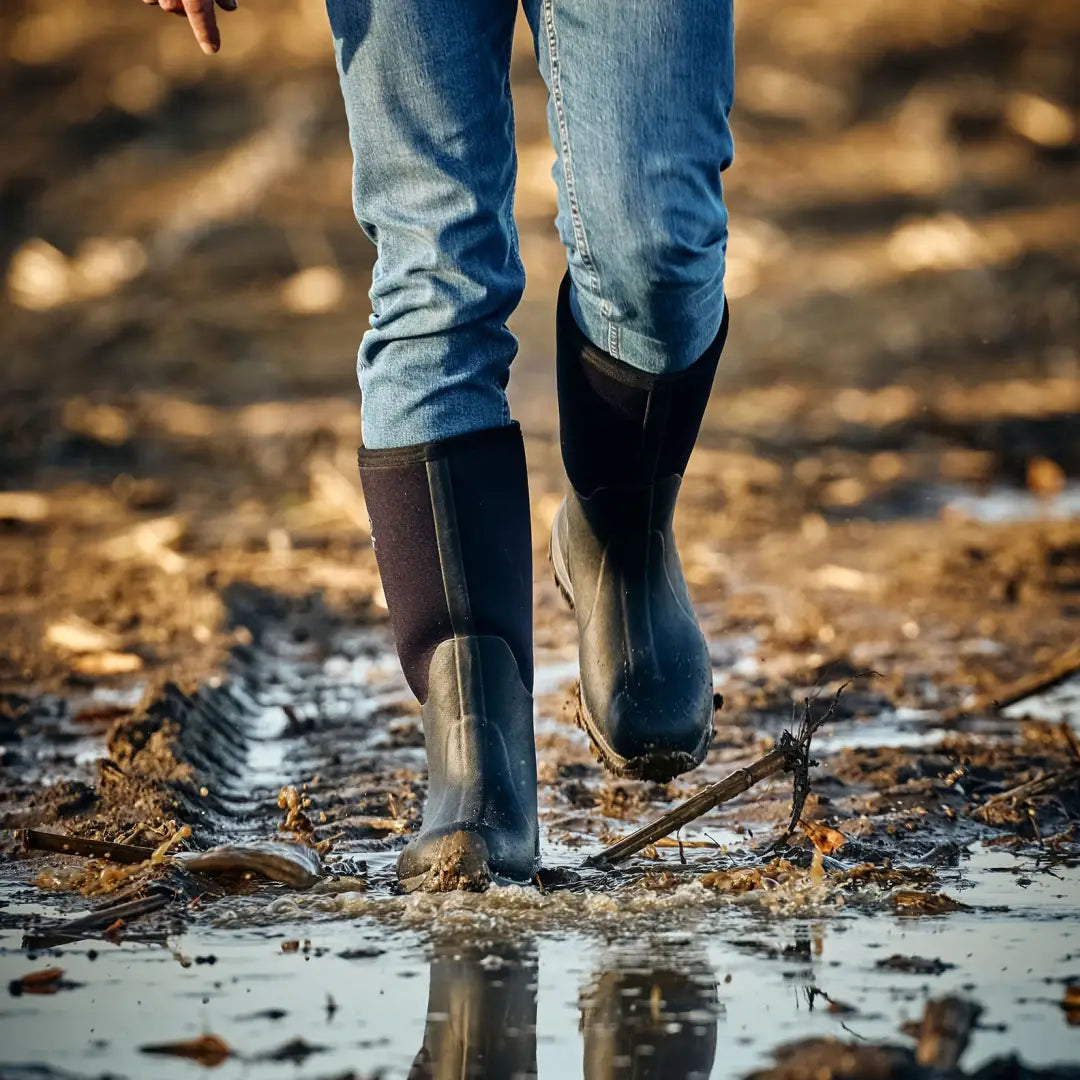 Mud-splashed waterproof boots from Grubs Bearline for country clothing and hunting trips
