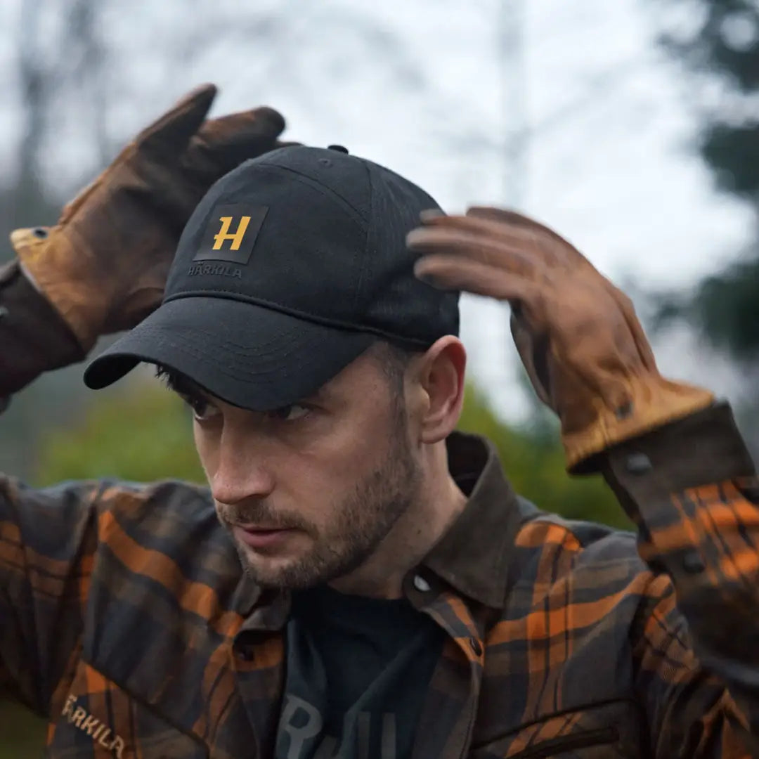 Black härkila instinct cap with logo, perfect for outdoor adventures