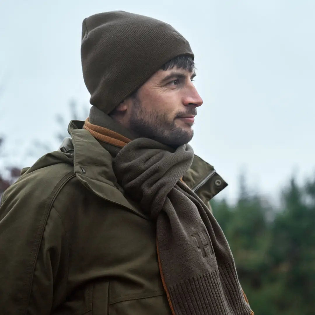 Man in olive green Härkila Reversible Beanie, perfect for country hunting clothing