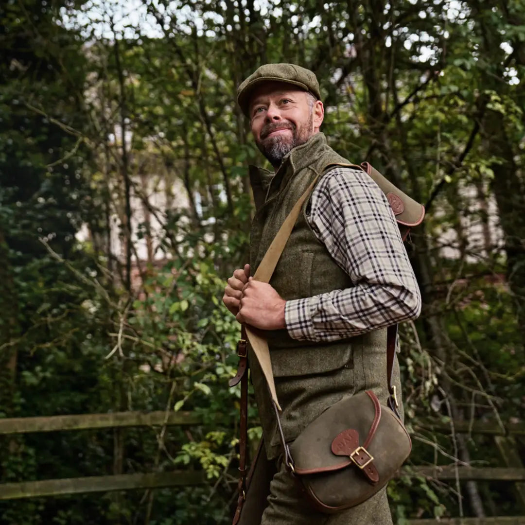 Man in tweed hunting attire wearing the Harkila Kenmore Waistcoat for outdoor adventures