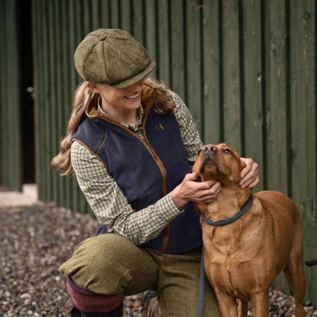 Woman petting brown dog in Harkila Sandhem 200 Ladies Waistcoat with wind-resistant check lining