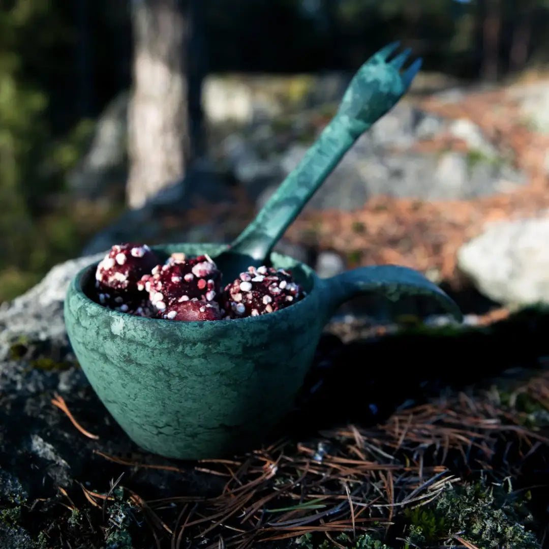 Verdigris-patinaed Kupilka Large Cup with berries and fork, perfect for outdoor dining
