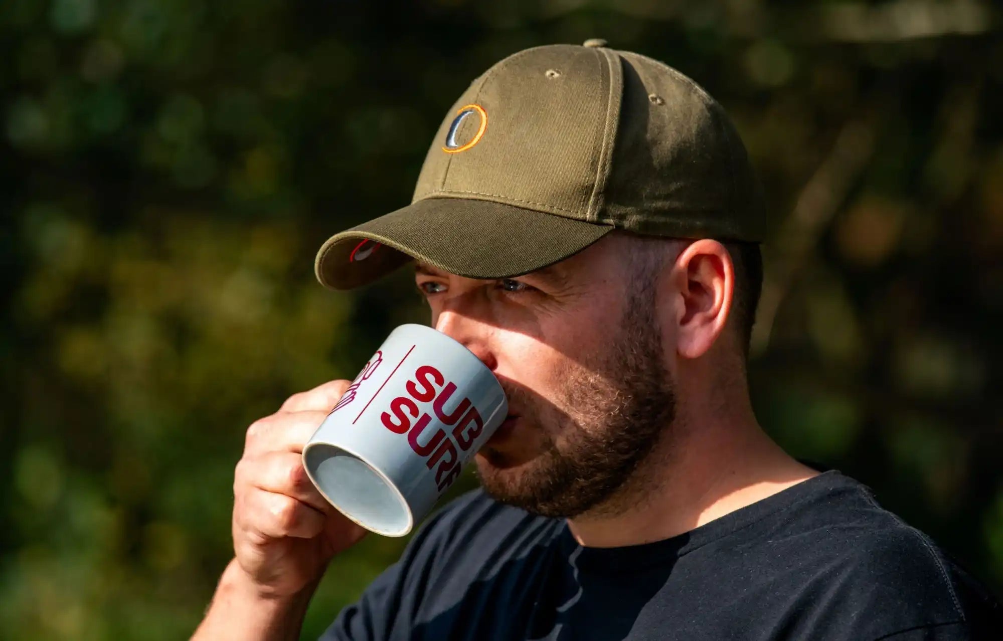 Man enjoying a beverage while wearing a Sleek Speero Baseball Cap