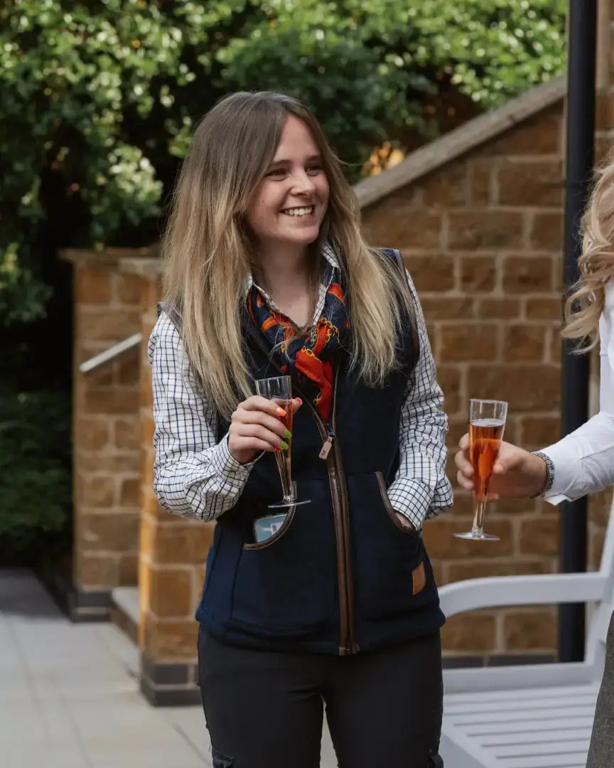 Woman in forest ladies fleece gilet with plaid shirt and rosé drink casual style