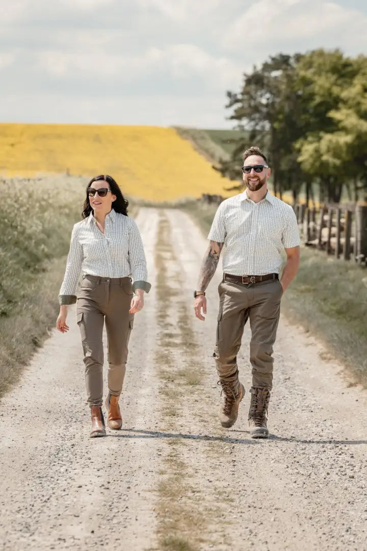 Couple walking on a dirt road.