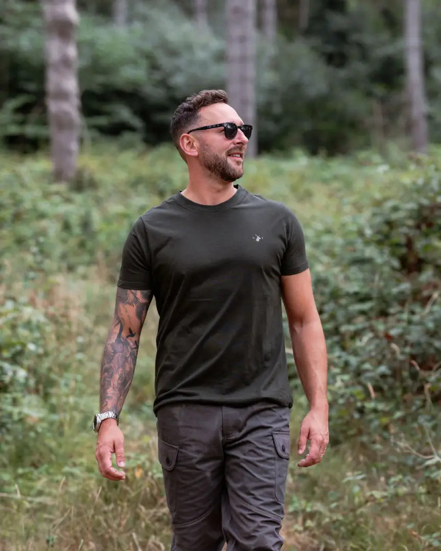 Man in dark green forest clothing 2-pack t-shirt and cargo pants for outdoor style