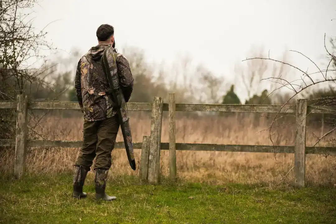 Camouflaged hunter ready with a rifle in Jack Pyke Rannock Waterproof Hunting Jacket