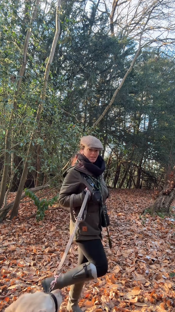 Load video: Person walking a dog on a leash through a forest