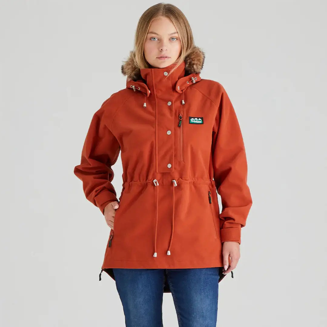 Woman wearing rust-colored monsoon nordic smock hooded anorak jacket for outdoor style