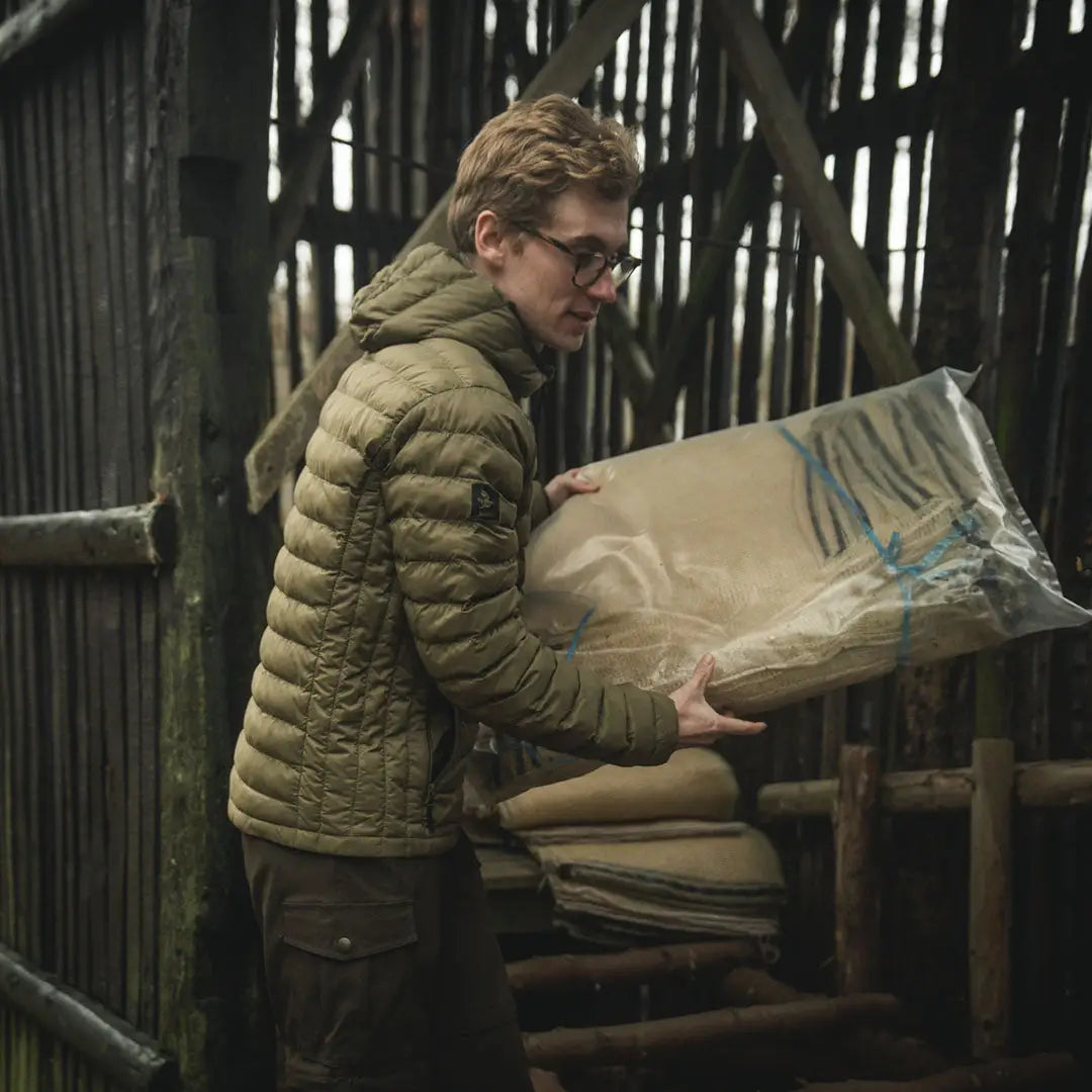 Man carrying wrapped mats in Seeland Fahrenheit jacket with synthetic insulation and YKK zippers
