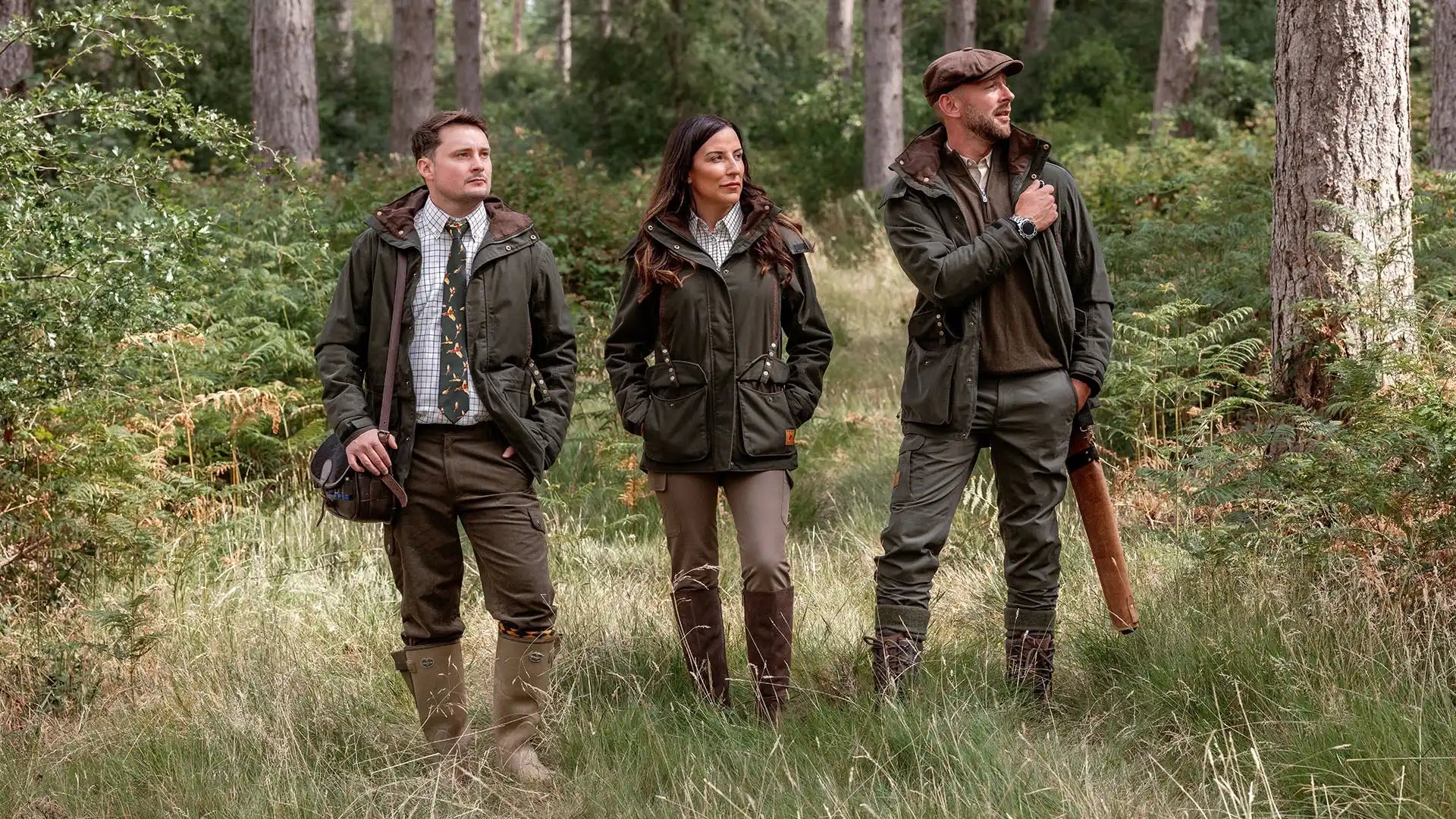 Three people in outdoor wear in a forest.