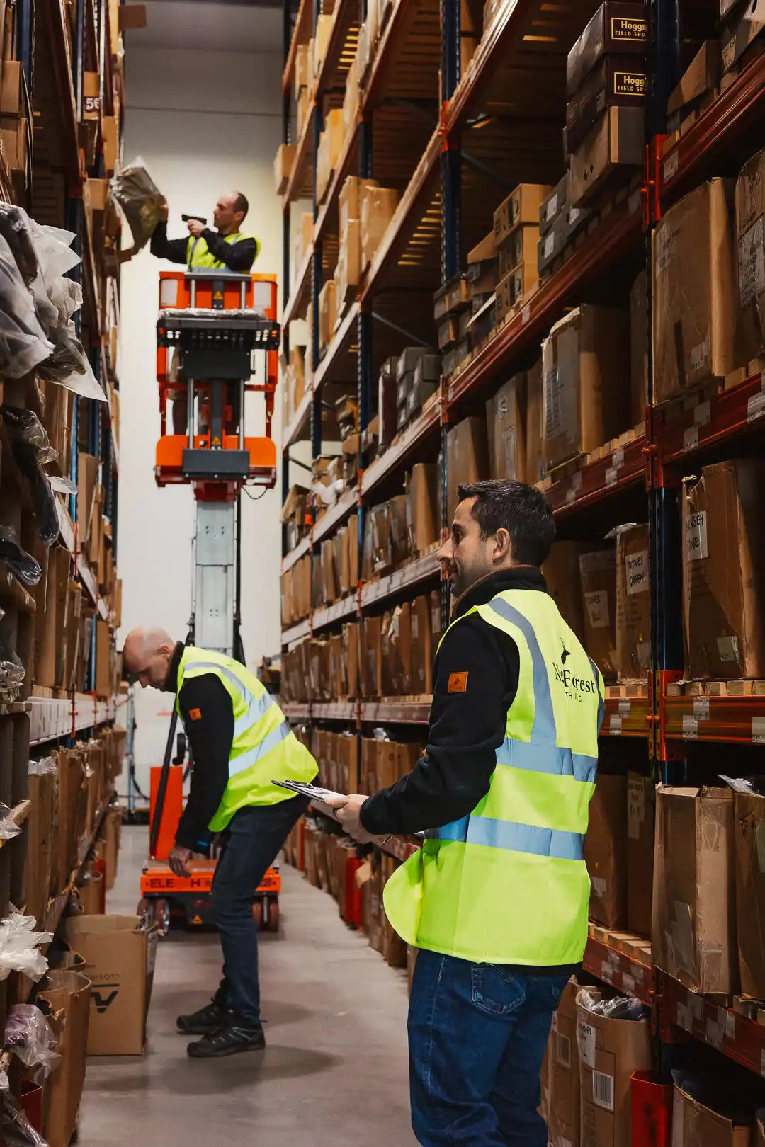 Workers in a warehouse picking and sorting items from shelves.
