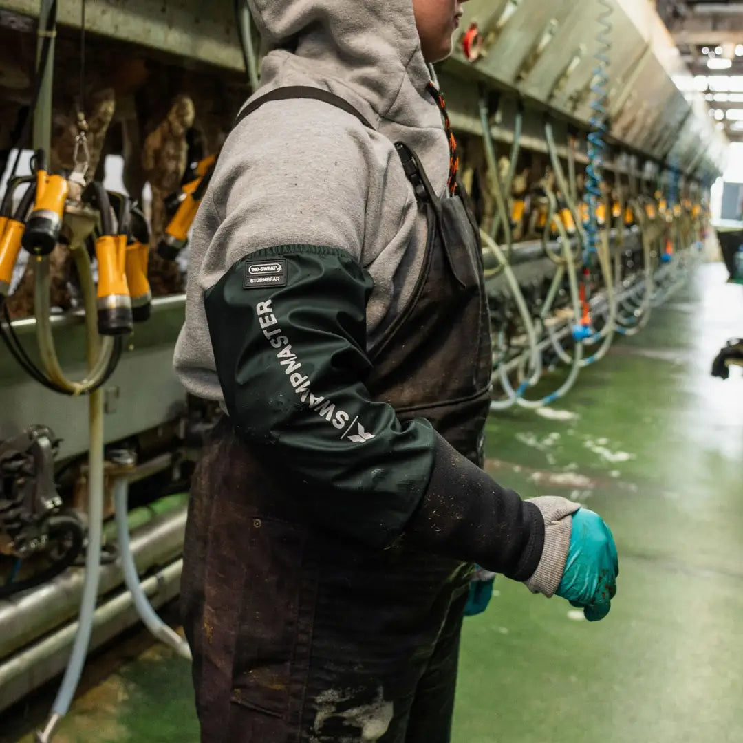 Person wearing grey hoodie and teal glove with Xpert Swampmaster Stormgear dairy sleeves for hunting