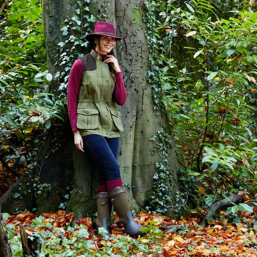 Woman in alan paine rutland ladies tweed vest with maroon top and green wellington boots