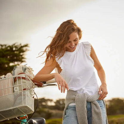 Woman with long brown hair smiling by a bike, rocking Ariat Womens Ludlow for outdoors