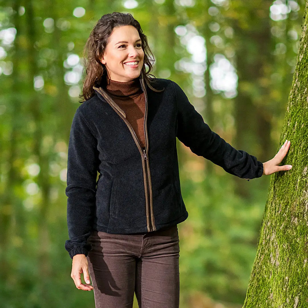 Woman in a black fleece jacket with two lower hand pockets, exploring a forest