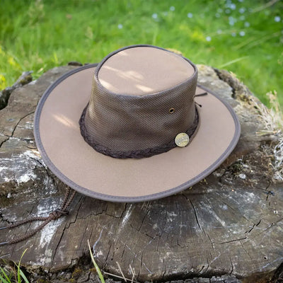 Wide-brimmed beige Barmah Drovers hat made of lightweight canvas material on wood