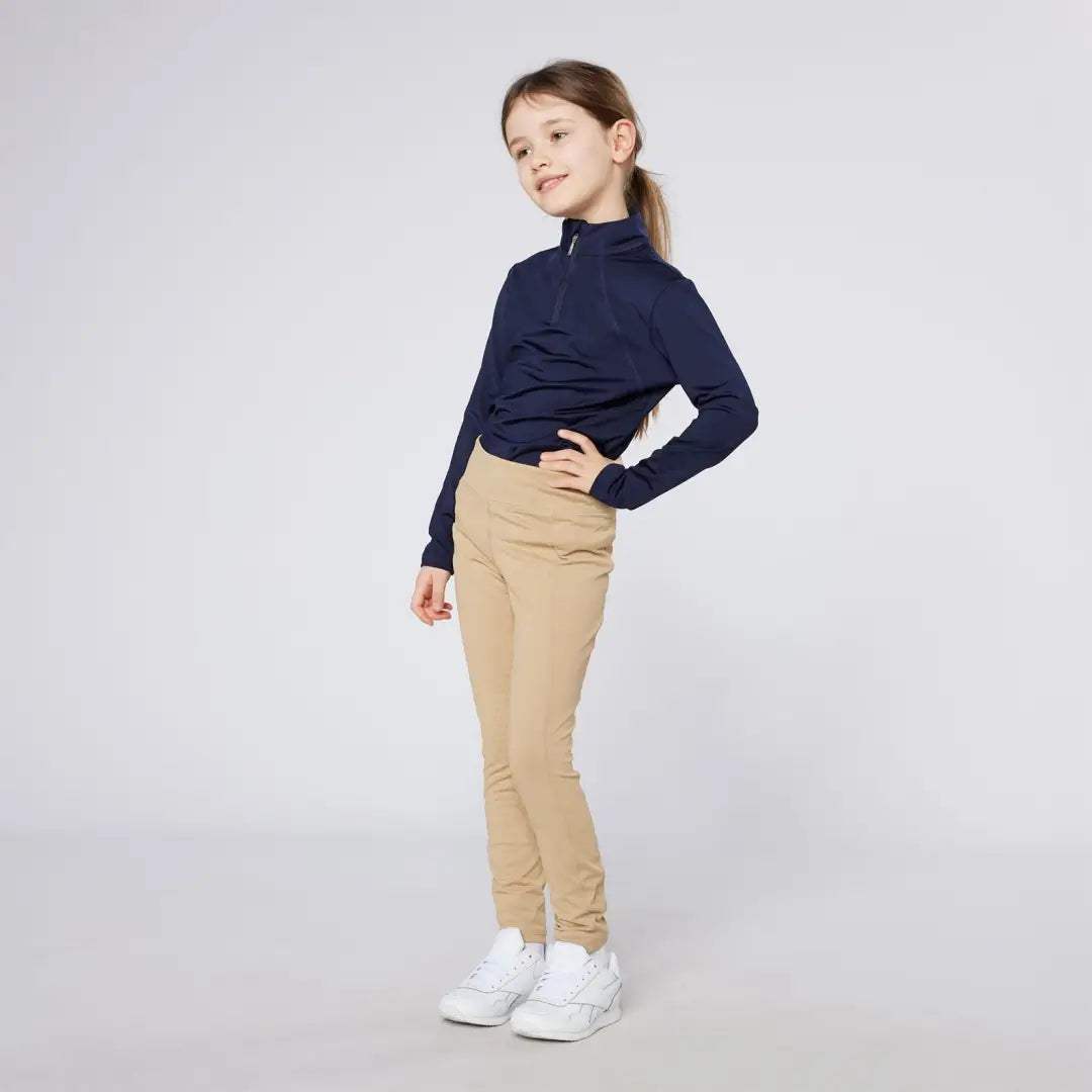 Girl in navy top and tan pants wearing Cameo Junior Core Tights style