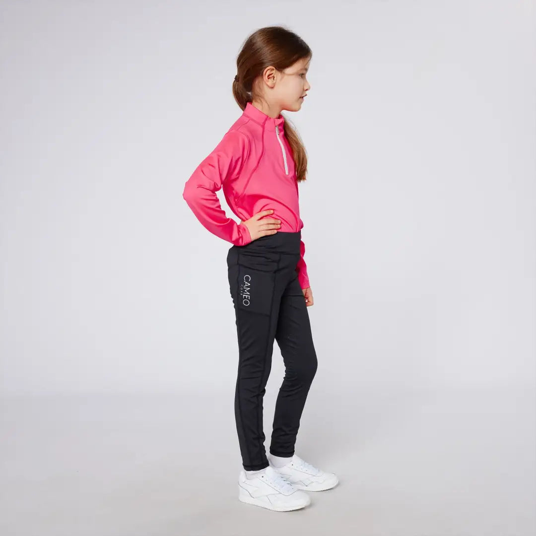 Girl wearing pink long-sleeved shirt and black leggings in Cameo Junior Core Tights, perfect for outdoors country clothing