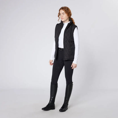 Woman wearing Cameo Performance Tights in black vest, pants, and boots for performance riding