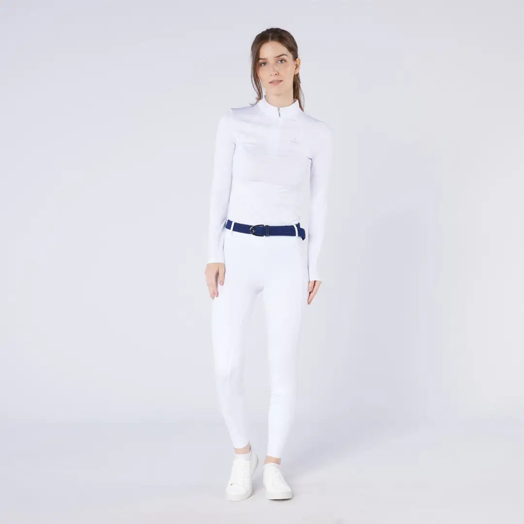 Woman in white athletic wear with navy belt and white shoes, perfect for country clothing outdoors