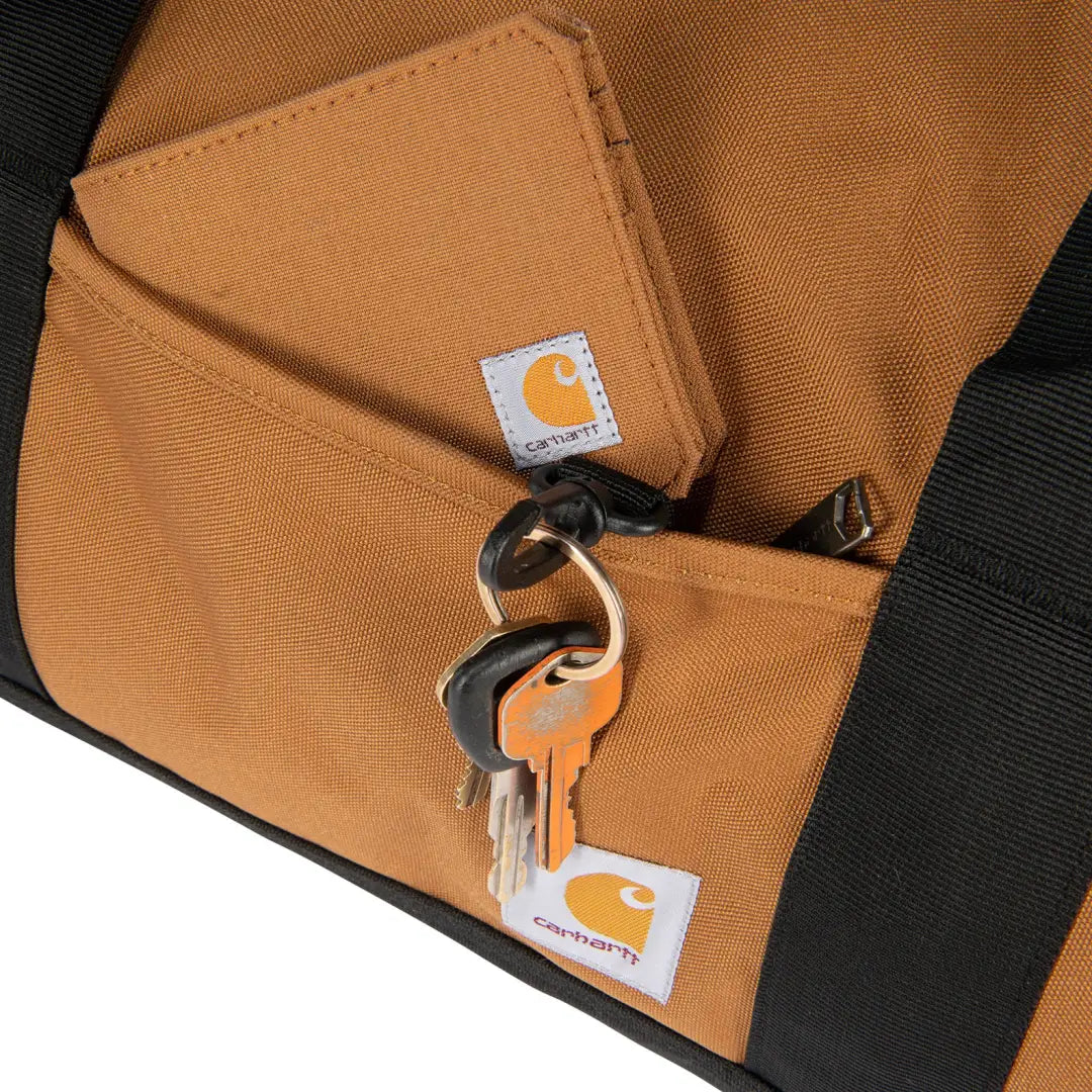 Brown Carhartt keychain with keys and pouch on 40L Classic Round Duffel