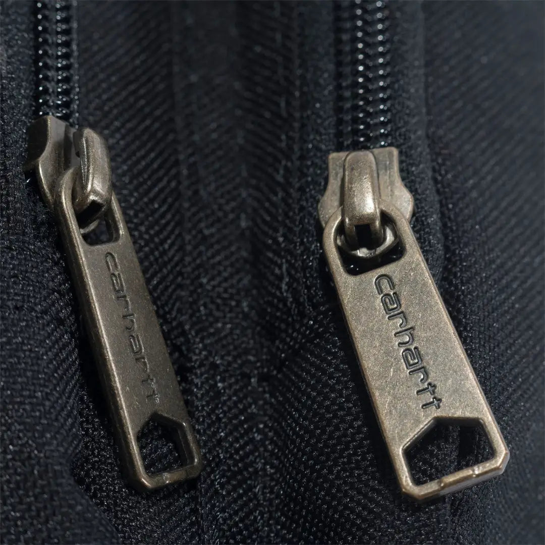 Carhartt zipper pullers on black fabric of crossbody zip bag