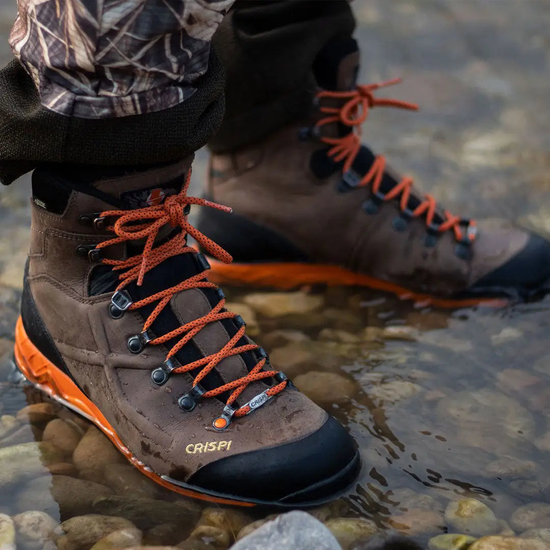 Crispi Valdres S.E. GTX boot with orange laces on rocky terrain by water for long periods