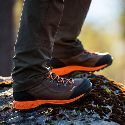Crispi Valdres S.E. GTX hiking boots with gray uppers and orange soles on rocks