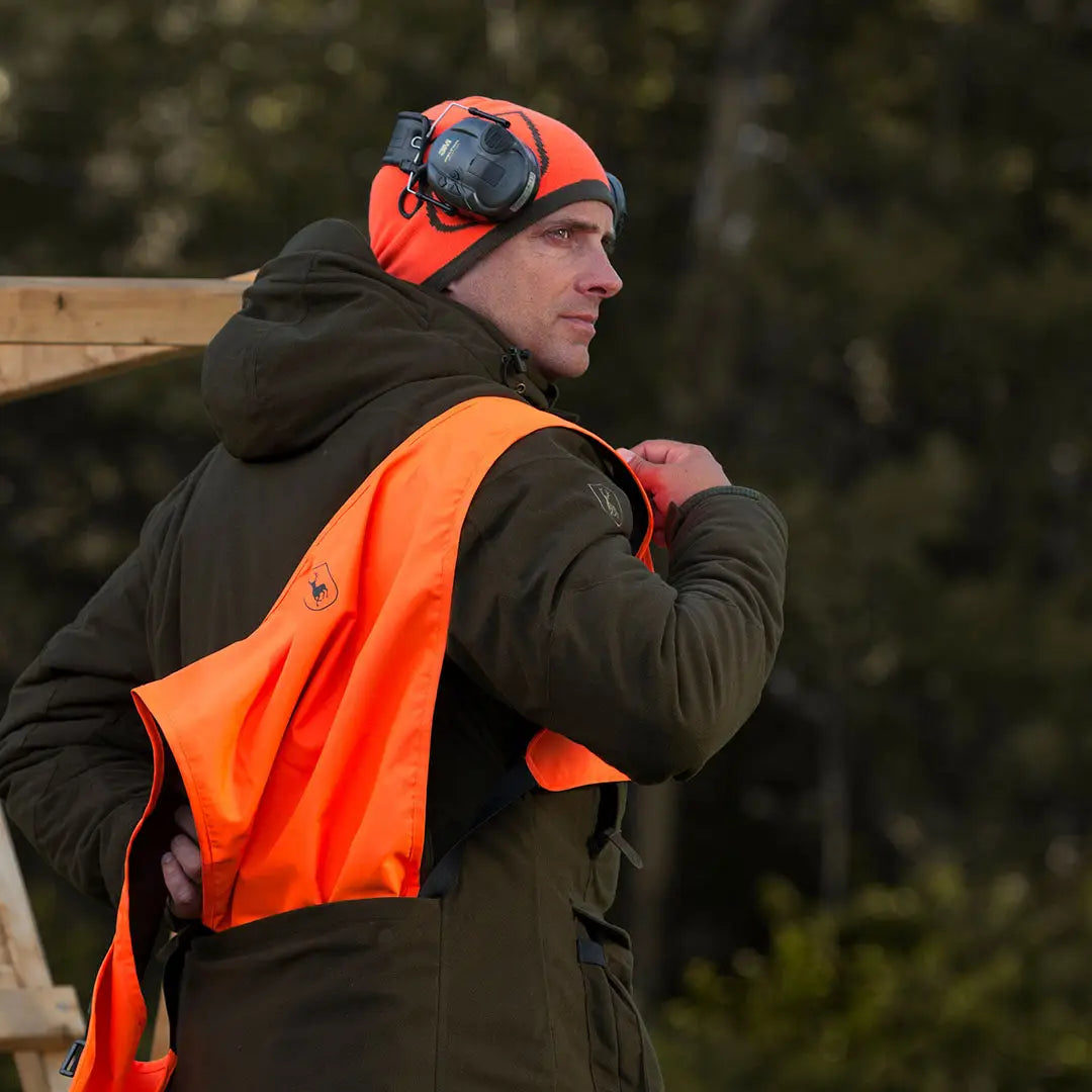 Hunter in orange safety vest and earmuffs wearing a Cumberland Knitted Beanie
