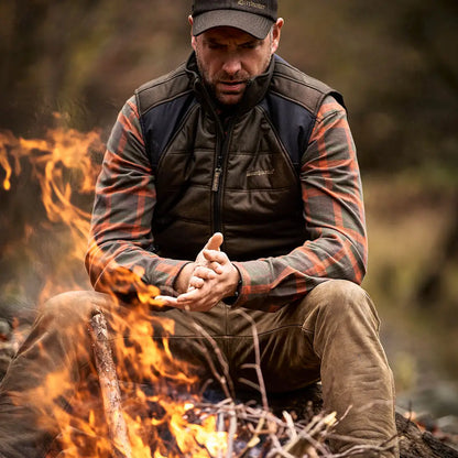 Man in outdoor clothing by campfire wearing Deerhunter Ethan Shirt for adventure
