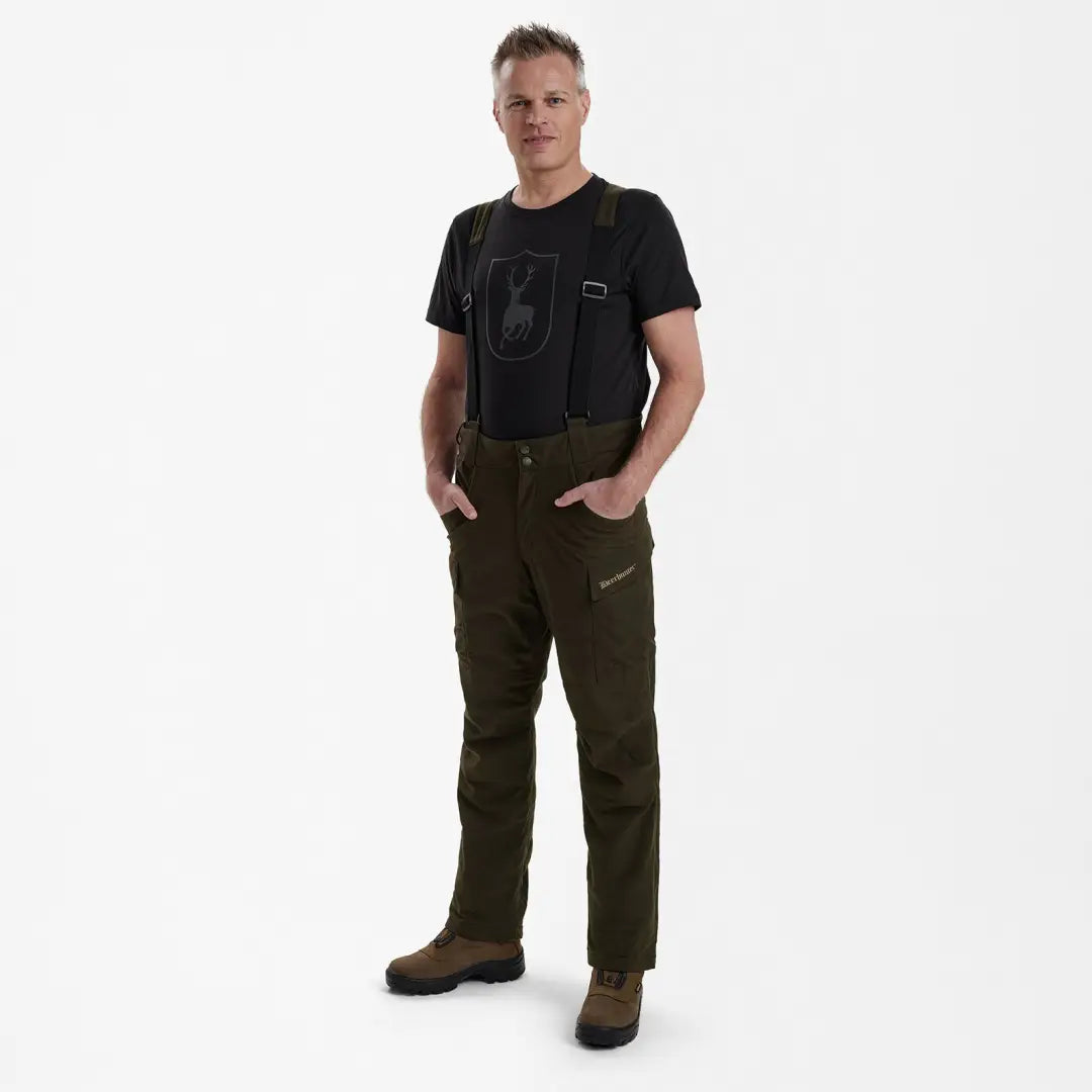 Man wearing Deerhunter Heat Game Trousers with dark green pants and suspenders