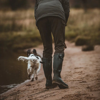 Person walking a small dog on a muddy path in Deerhunter Lady Ann Full Stretch Trousers