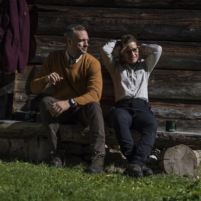 Two people in Deerhunter Lady Ann trousers sitting outdoors on a wooden structure