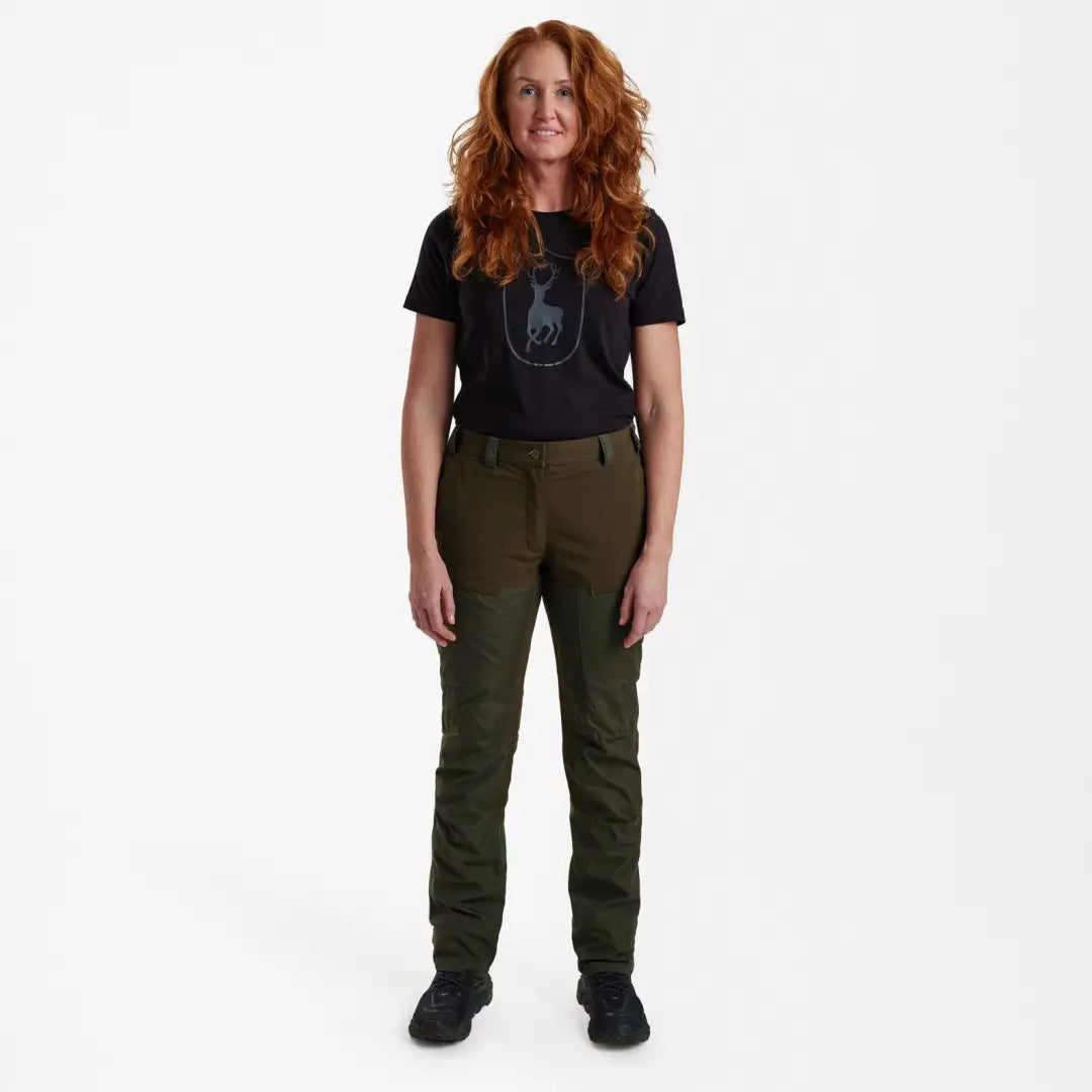 Woman with curly red hair in black tee and olive pants wearing Deerhunter Lady Ann Trousers
