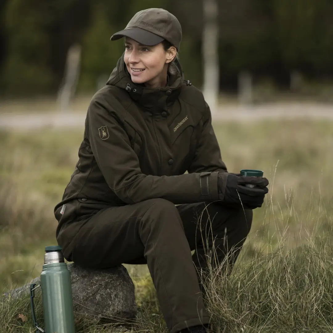 Woman in Deerhunter Lady Mary Jacket sitting on a rock, enjoying a mug