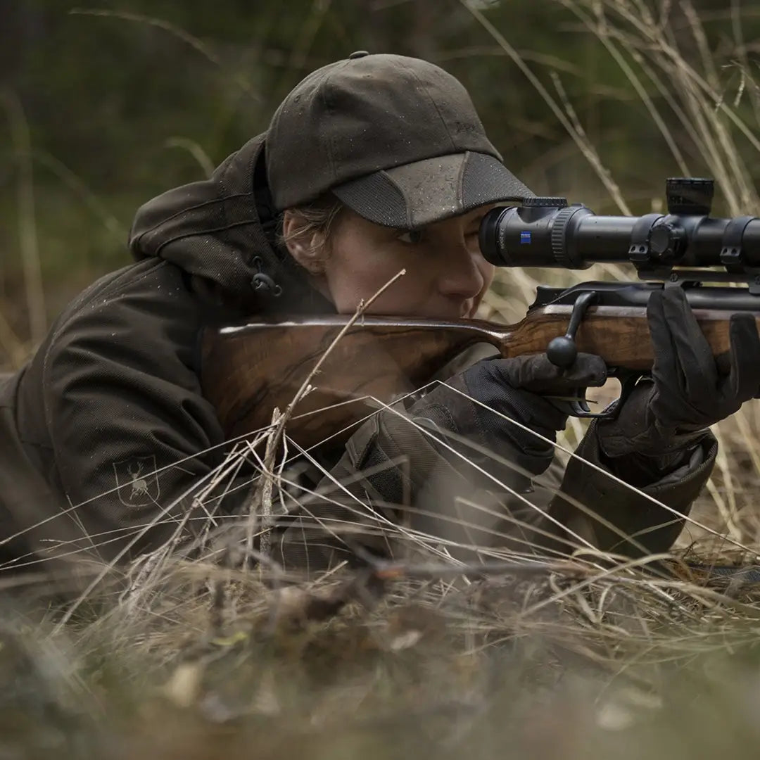 Person in camouflage aiming sniper rifle while wearing Lady Mary jacket