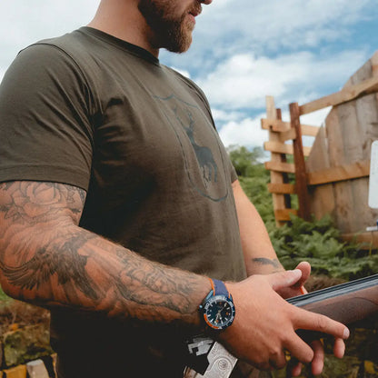 Man with a shotgun wearing a Deerhunter logo on country clothing for hunting adventures
