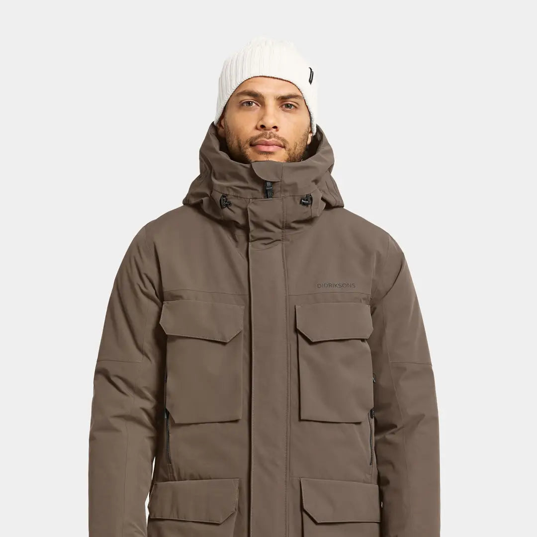 Man in light brown Didriksons Drew Parka with white beanie, perfect for chilly days