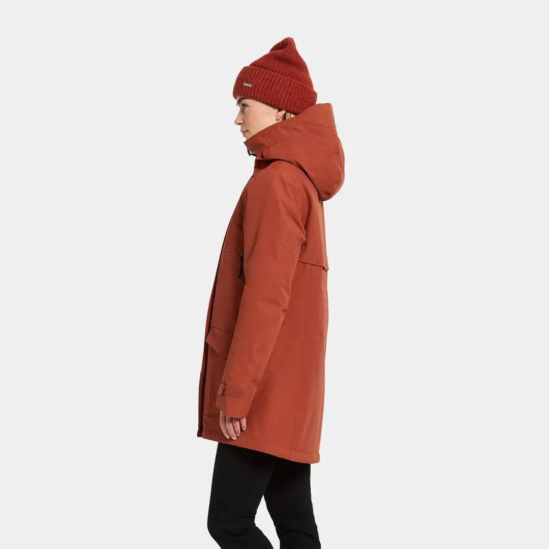 Rust-colored Didriksons Frida Womens Parka with hood and matching knit beanie, perfect sporty mid-length parka