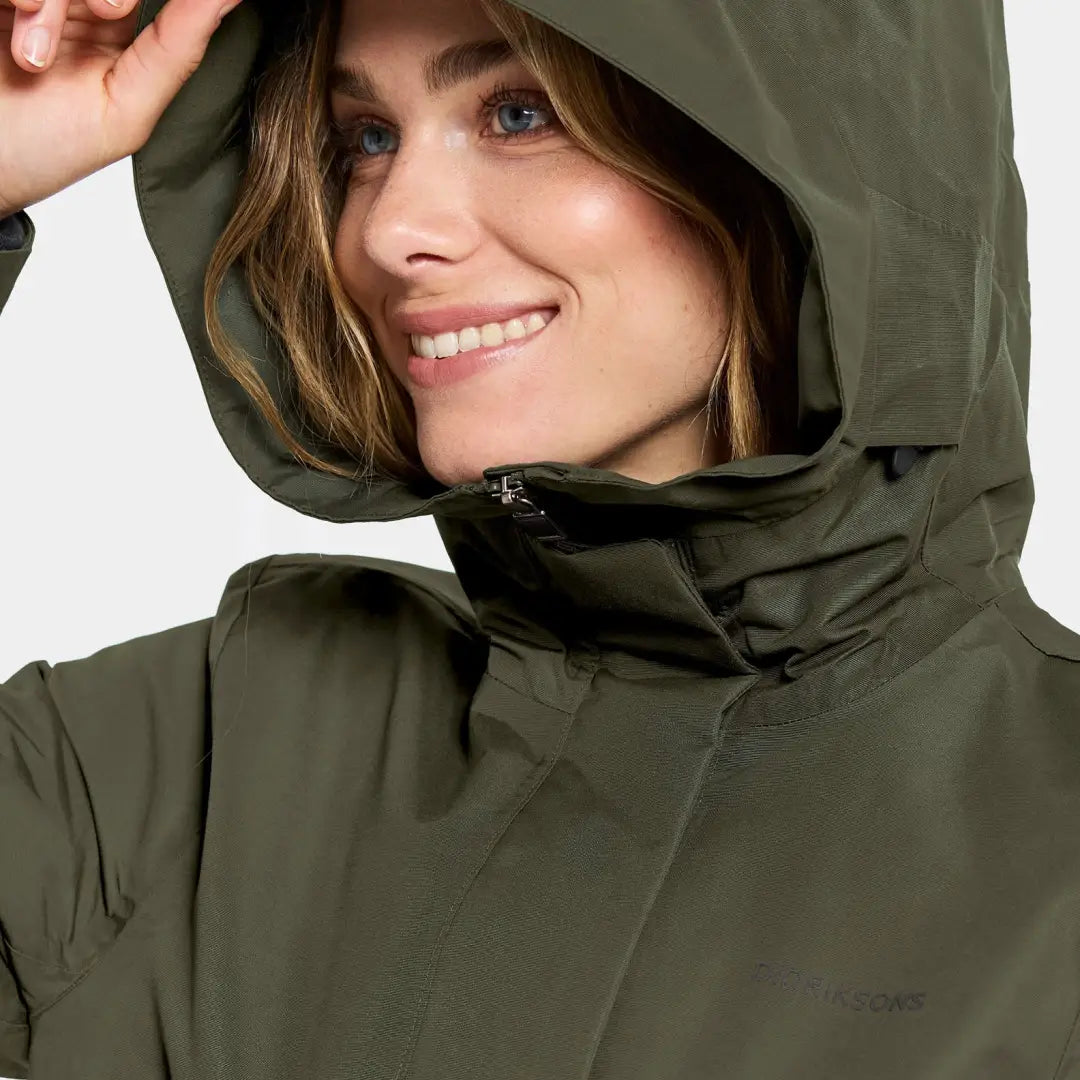 Woman in dark olive green waterproof sporty mid-length parka with zip front
