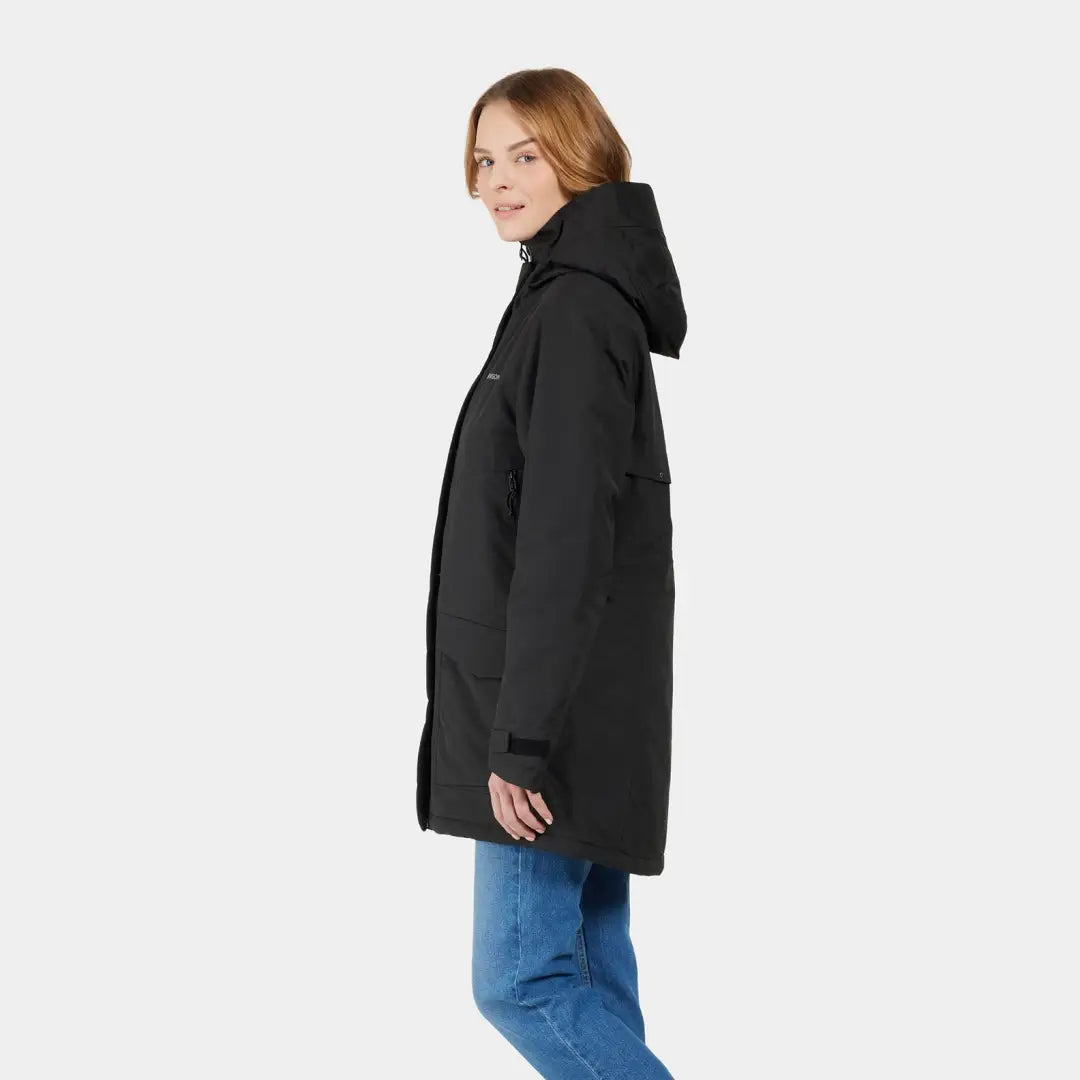 Woman in a sporty mid-length black hooded parka and blue jeans showcasing Didriksons Frida Womens Parka 7