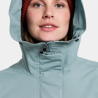 Woman in light blue sporty mid-length parka with red beanie - Didriksons Frida Womens Parka