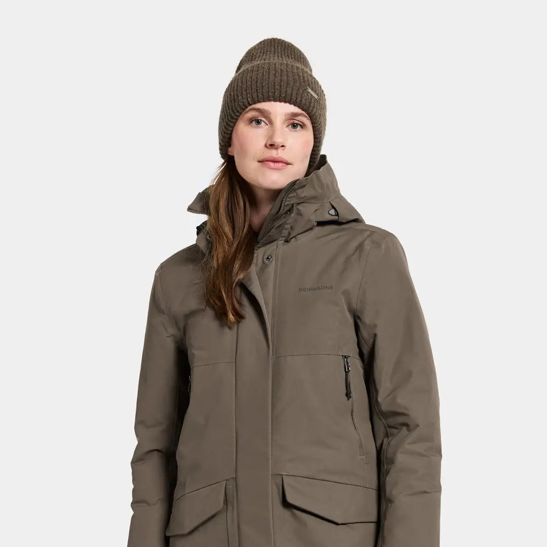 Woman wearing a sporty mid-length parka and ribbed knit beanie for winter warmth