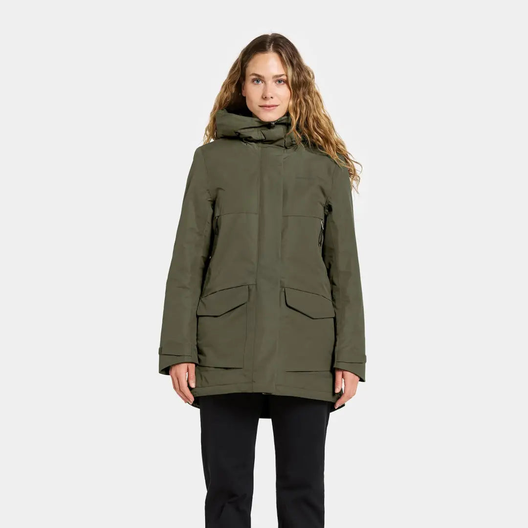 Woman in sporty mid-length parka with hood, front pockets, and high collar