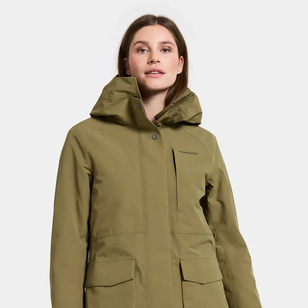 Woman wearing Didriksons Harriet waterproof parka with hood and pockets, perfect for country clothing and hunting