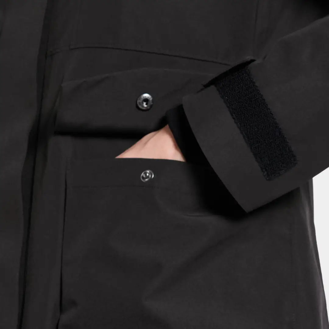 Person’s hand in Didriksons Harriet black parka pocket with Velcro cuff, perfect for country hunting